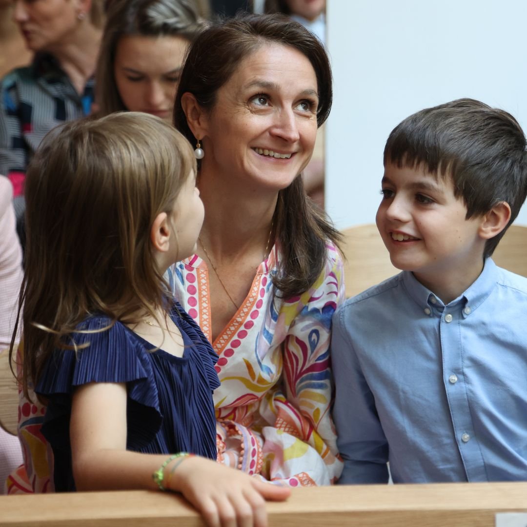 Familien-Messen Bild Mutter lächelt in Kirche, neben ihr ihre lachenden Kinder